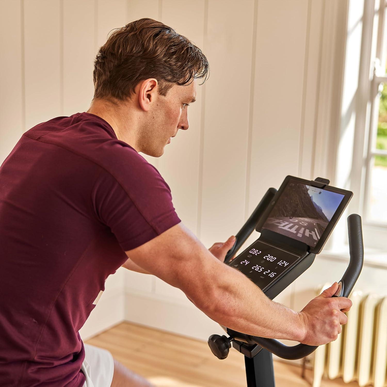 imageReebok Fitness Stationary Bike Bluetooth Compatible Indoor Cycling Bike 24 Resistance Levels 12 Workouts Upright Exercise Bike with Gel Pad SaddleBlackFR30