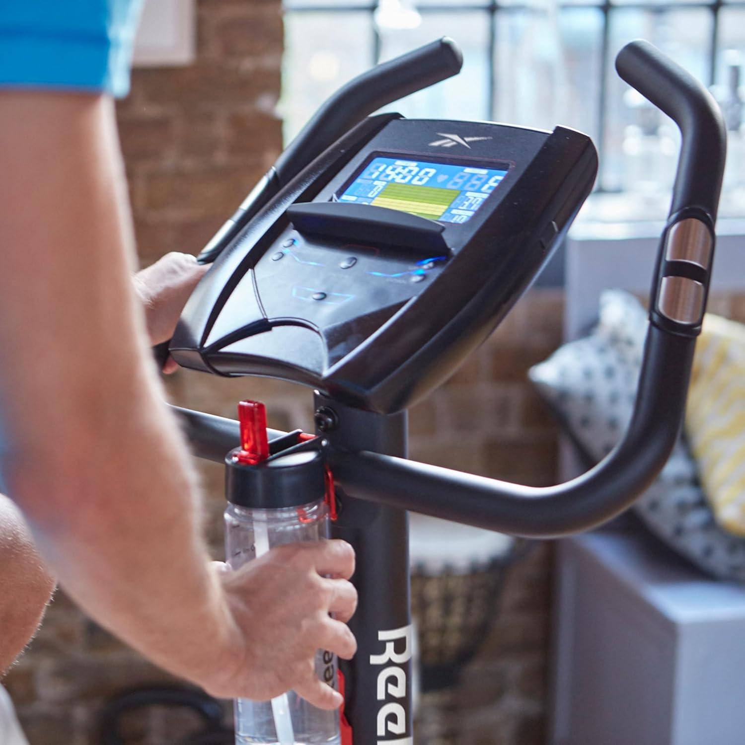 imageReebok Fitness Stationary Bike Bluetooth Compatible Indoor Cycling Bike 24 Resistance Levels 12 Workouts Upright Exercise Bike with Gel Pad SaddleBlack