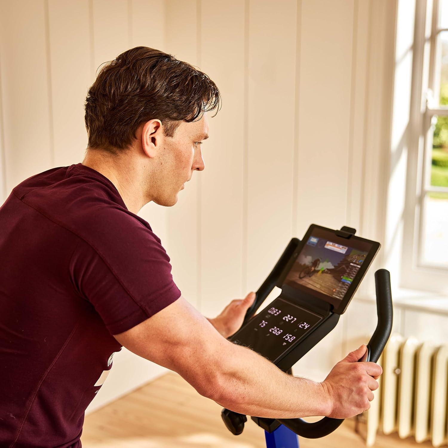imageReebok Fitness Stationary Bike Bluetooth Compatible Indoor Cycling Bike 24 Resistance Levels 12 Workouts Upright Exercise Bike with Gel Pad SaddleBlue
