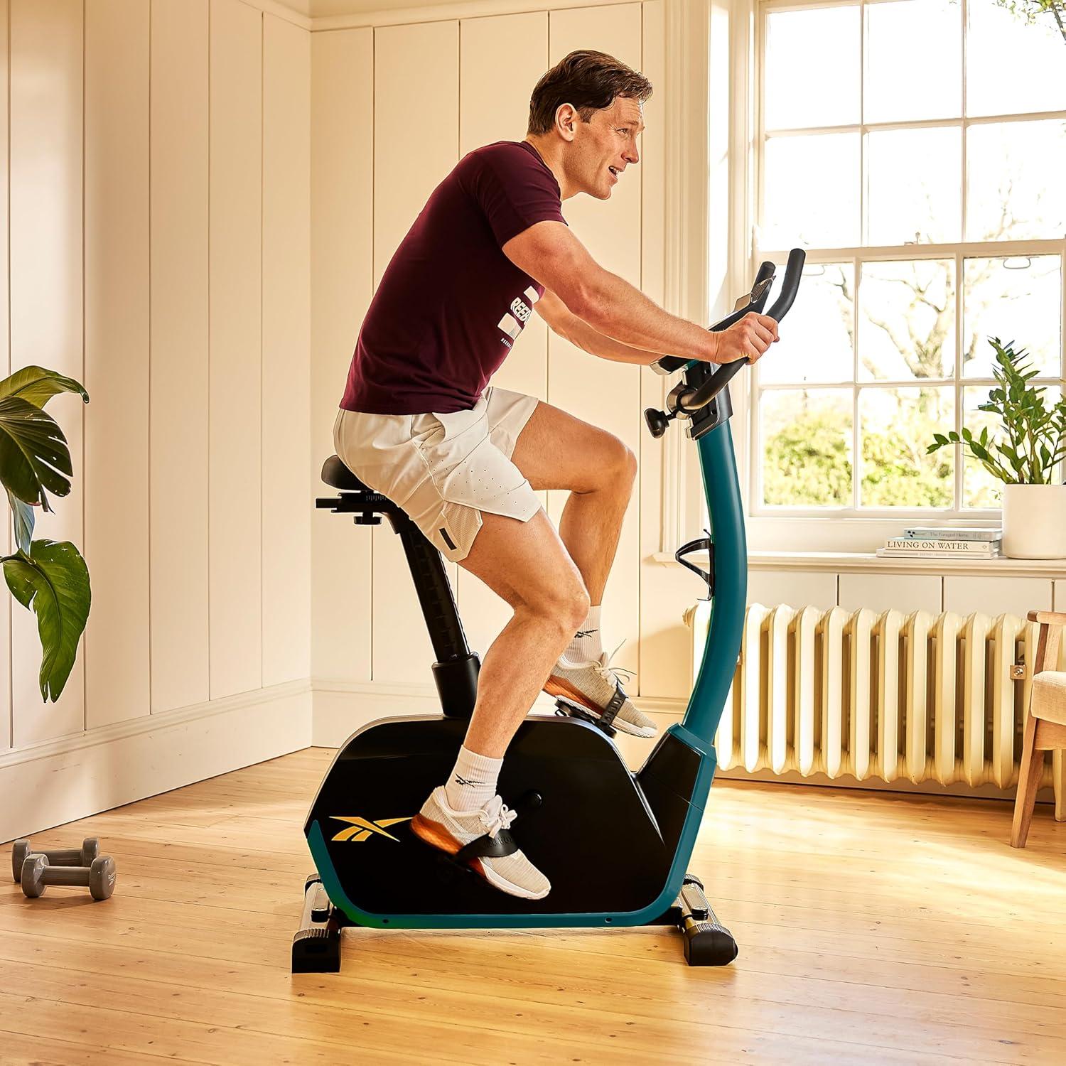 imageReebok Fitness Stationary Bike Bluetooth Compatible Indoor Cycling Bike 24 Resistance Levels 12 Workouts Upright Exercise Bike with Gel Pad SaddleGreen