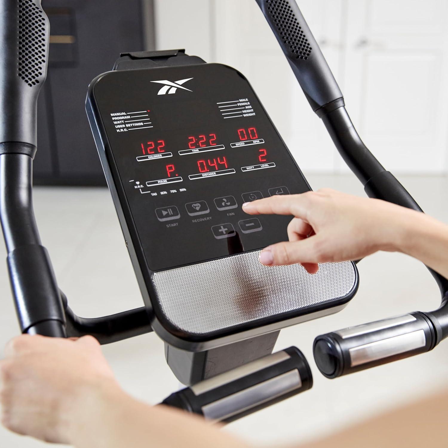 imageReebok Fitness Stationary Bike Bluetooth Compatible Indoor Cycling Bike 24 Resistance Levels 12 Workouts Upright Exercise Bike with Gel Pad SaddleSilver